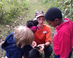 Diane DuBois examines a walnut with 1st grade students from Lafayette Preparatory Academy.