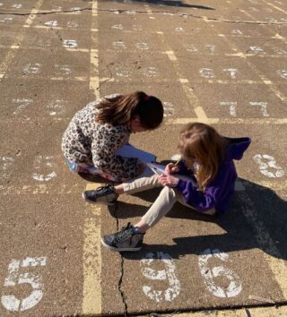 Girls taking notes in schoolyard