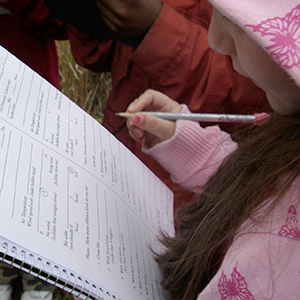 Girl recording observations in a notebook