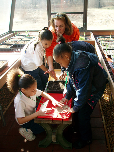 Mary leads students in greenhouse