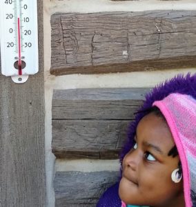 Girl posing next to thermometer